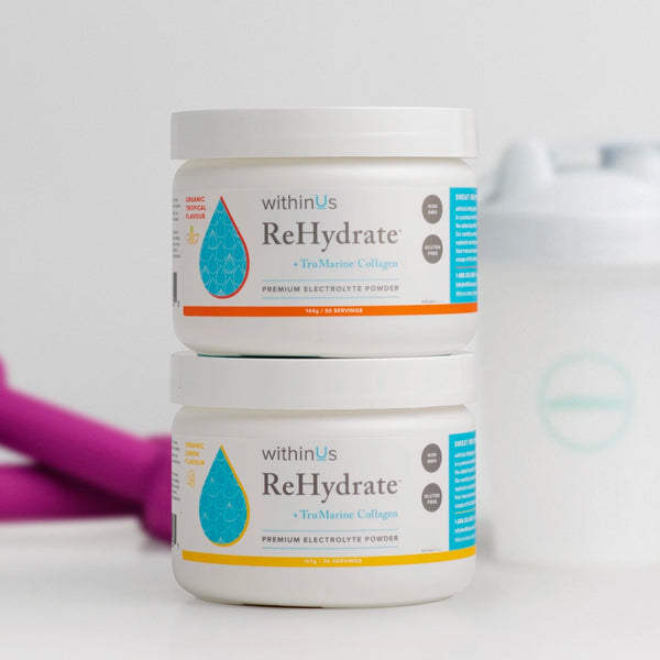 Two jars of ReHydrate™, Tropical and Lemon displayed next to weights.